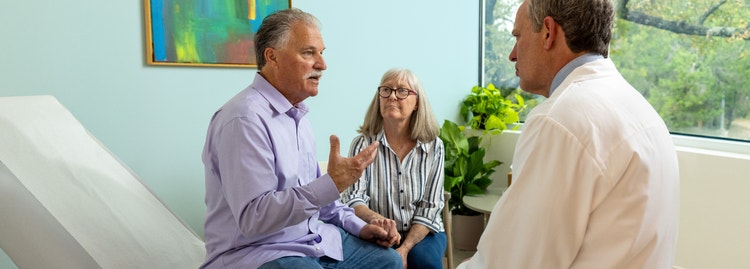 Older man speaking with his partner and a doctor during a medical appointment