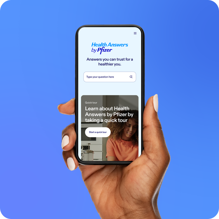 Hand holding a smartphone displaying Health Answers by Pfizer on the screen