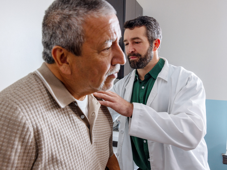 Doctor examining an older male patient during a clinical checkup