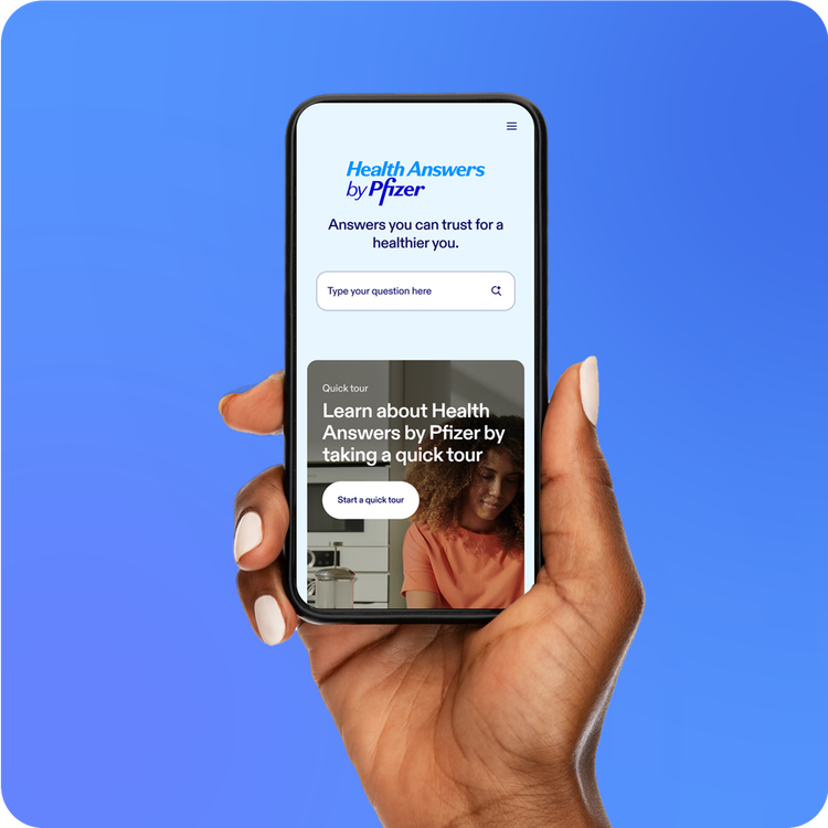 Hand holding a smartphone displaying Health Answers by Pfizer on the screen, Picture