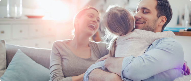 smiling parents holding their daughter demonstrating their relief