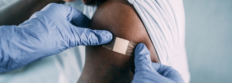 A healthcare professional applying a bandage to an arm